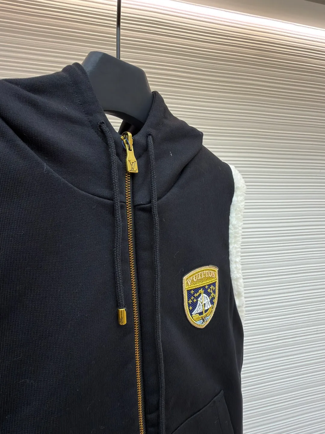 LOUIS VUITTON embroidered reversible hooded vest ●Original version: purchased and developed by 14599 ●Item number: 1681399-C00 ●Fabric: lamb wool fabric ●Technology: embroidery production ●Color: black/white ●Version: fitted version ●Weight: about 1040 grams ●Size: S-M-L-XL ●Description: This vest adopts a double-sided design. One side is made of high-quality knitted fabric, which is crisp, stylish, skin-friendly and comfortable; the other side is made of imitation lamb wool, which is fluffy, soft and has good warmth retention. The hooded part is made of knitted fabric of the same color and is equipped with a two-way zipper with a metal zipper puller, which is smooth and durable. The flip design of cotton knitted surface and comfortable suede surface is very ingenious. It uses advanced double-sided weaving and composite technology to perfectly integrate the two materials and make the transition natural when switching; the shield logo patch uses high-precision patching technology, with neat edges and clear and three-dimensional patterns; the embroidered logo on the back uses fine embroidery technology, with fine and even stitches, and the logo is perfectly integrated into the back design; the drawstring hood uses high-quality drawstrings and precision sewing technology, which not only ensures the adjustment function of the hood, but also enhances the overall sense of leisure. The overall wiring is straight and delicate, the fabric is comfortable and soft, and the color is consistent without color difference. It can be matched with the same style to create a fashionable look and control various occasions. Customized accessories, complete with three standards, same style for men and women!